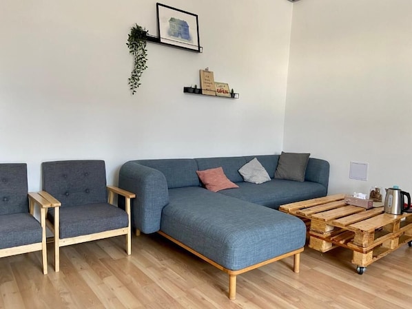 A modern living room with a grey sofa, two armchairs, and a coffee table.