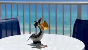 A decorative bird sculpture on a white table with a view of the ocean in the background. - Aqua Penthouse 2br/2ba with Infinite Ocean Views (Panama City Beach)