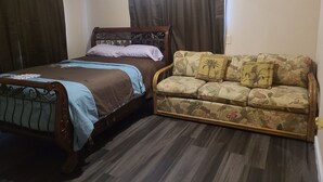 A bedroom with a bed, a sofa, and curtains. - Brightly Homely House  (Odem)