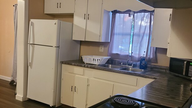 A kitchen with a stove, refrigerator, cabinets, and a microwave. - Brightly Homely House  (Odem)