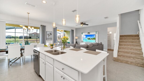 A modern kitchen with a central island, white cabinetry, and pendant lighting. - Golf Hideaway With Lake View! Modern Decor and Game Room With Multiple Options! #5pr2197 (Davenport)