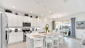 A modern kitchen with white cabinetry, stainless steel appliances, and a central island with seating. - Golf Hideaway With Lake View! Modern Decor and Game Room With Multiple Options! #5pr2197 (Davenport)