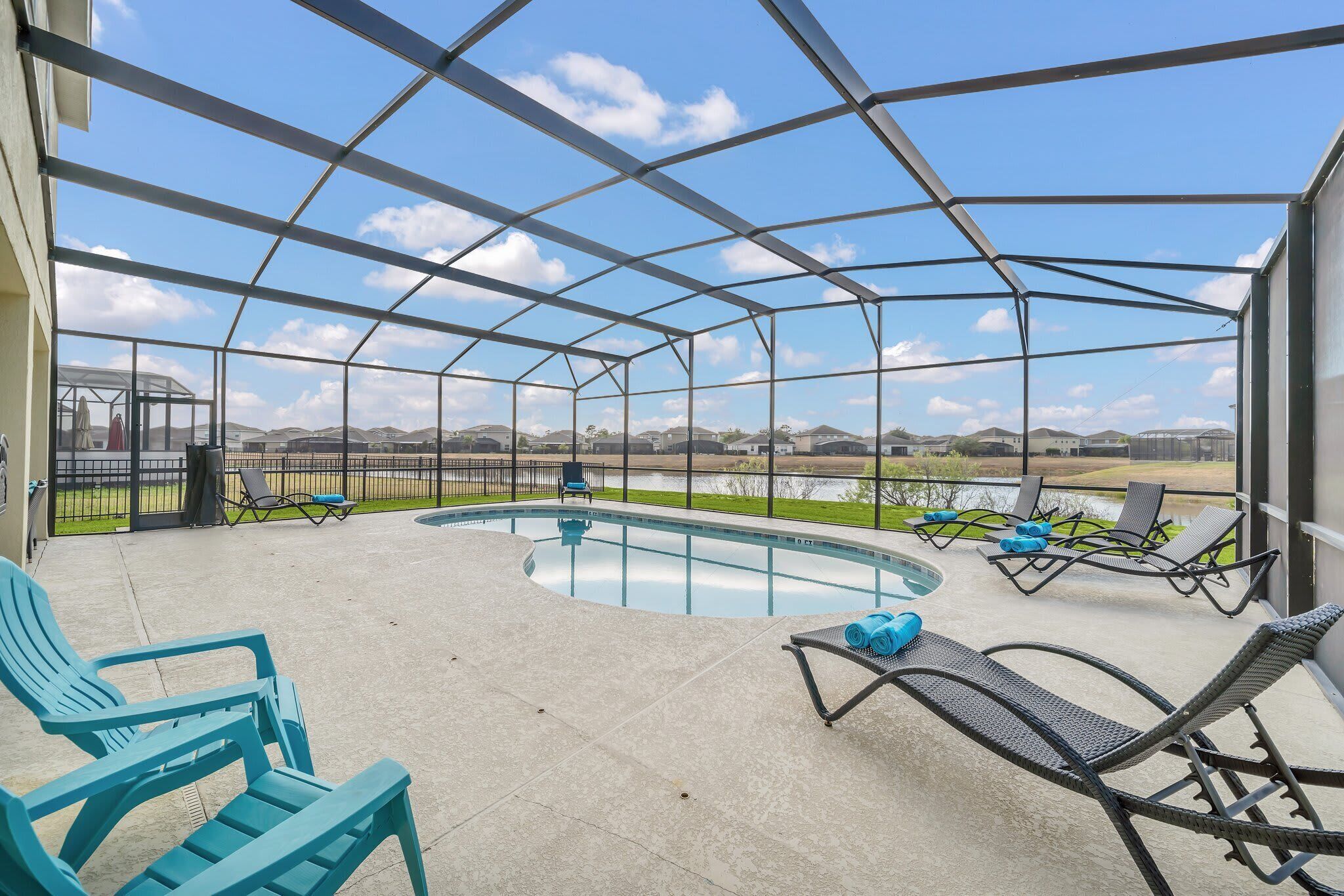 Un espace extérieur abrité comprenant une piscine, des chaises longues et une vue sur le paysage environnant.