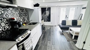 A modern kitchen with white cabinets, a black stove, and a patterned backsplash.