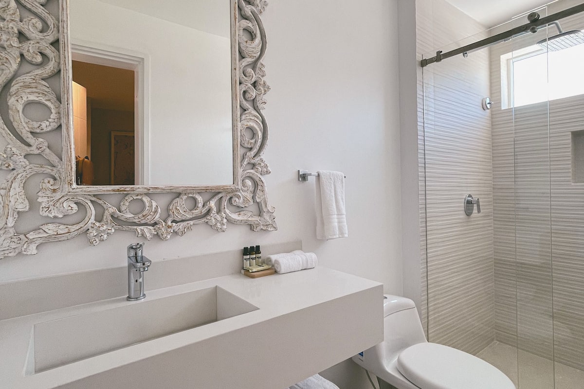 deluxe room | bathroom | shower, rainfall showerhead, towels