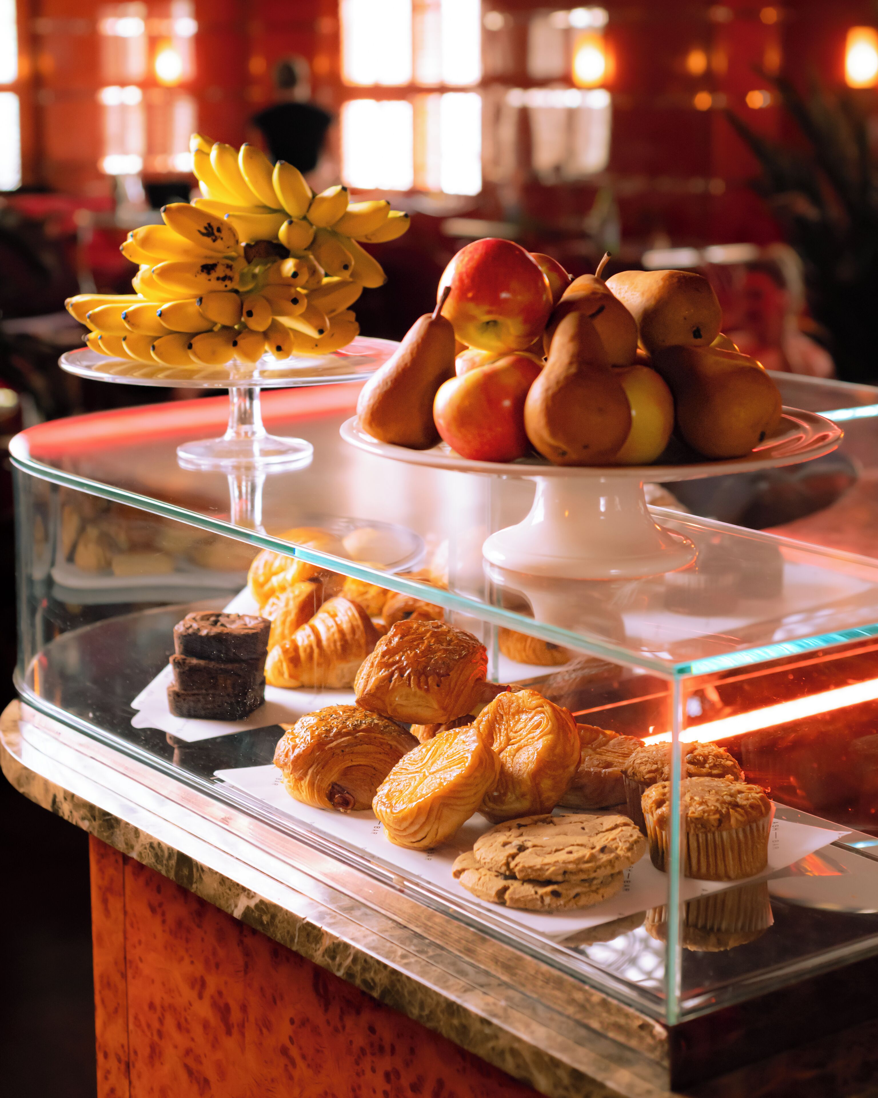Une vitrine contenant des pâtisseries et des fruits.