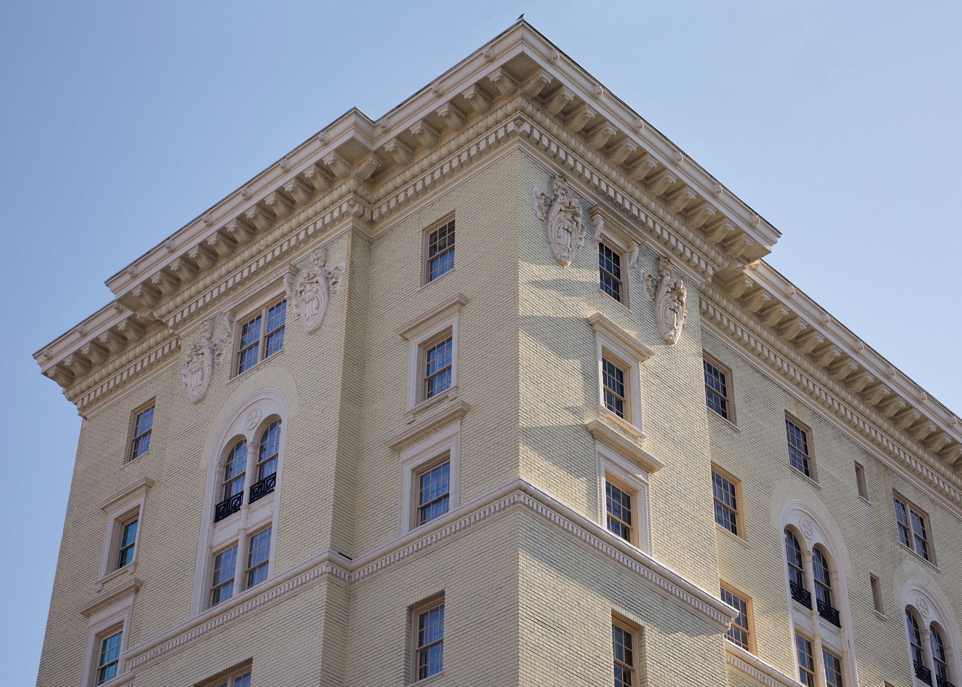 A multi-story building with a classical architectural style, featuring symmetrical windows and decorative moldings.