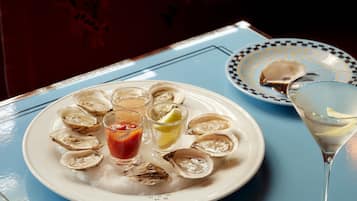 A table with plates of oysters, a martini glass, and a spoon.