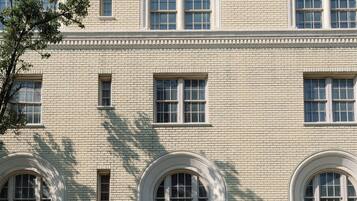 A large, multi-story building with arched windows and a brick facade.
