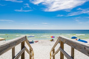 A wooden beach boardwalk leading to the ocean with several beach umbrellas and a person in a chair. - Ocean View; Fast Beach Access; Pool; Family-Sized Villa; Ideal Spot! (Pensacola Beach)