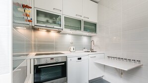 A modern kitchen with white cabinetry, a Bosch oven, a dishwasher, and a built-in microwave. - GuestReady Essential - Heartbeats (Porto)