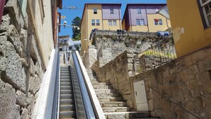 Eine schmale Steintreppe führt zu einem Gebäude, versehen mit einem Metallgeländer.