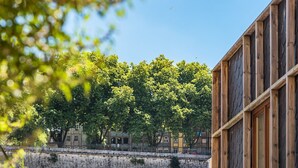 Ein Blick auf ein Gebäude mit einer Steinwand und Bäumen im Hintergrund.
