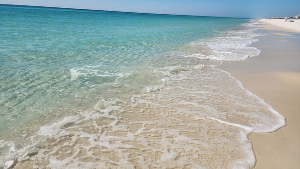 Una playa con agua turquesa cristalina y arena blanca.