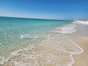 A beach with clear turquoise water and white sand.