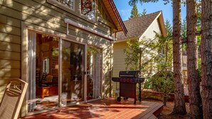 A wooden deck with a grill and a sliding glass door leading to a room. - Right across from the pool & hot-tub! (Parksville)