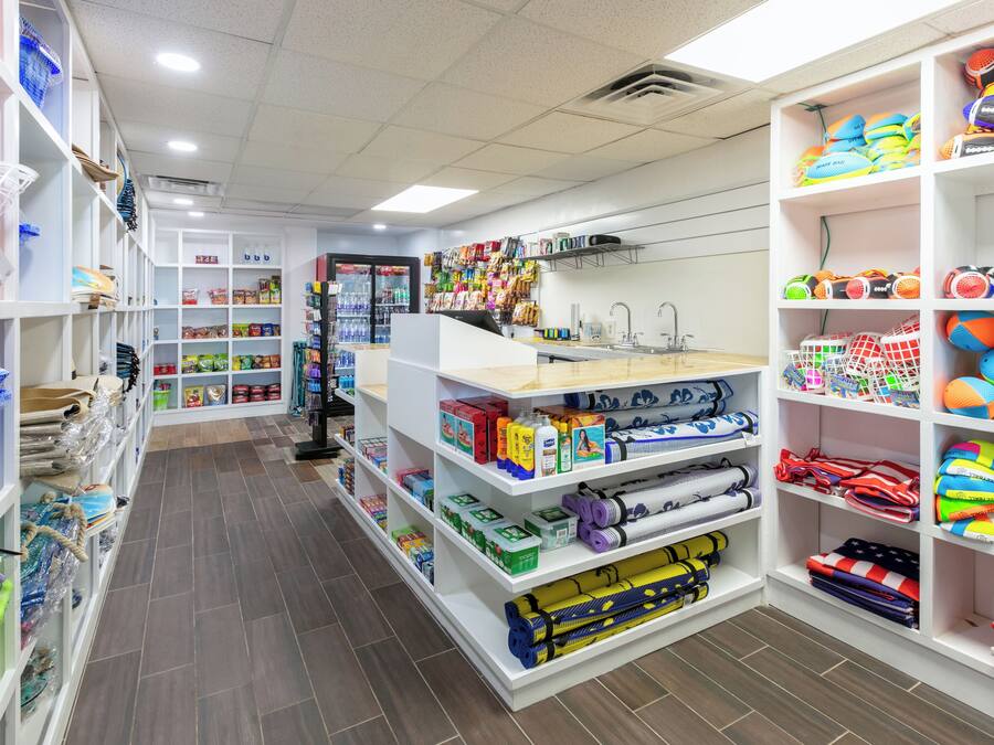A brightly lit store with shelves stocked with various items including sports equipment, toys, and household goods.