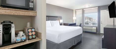 Hotelkamer met een bed, een magnetron, een koffiezetapparaat en een minibar.