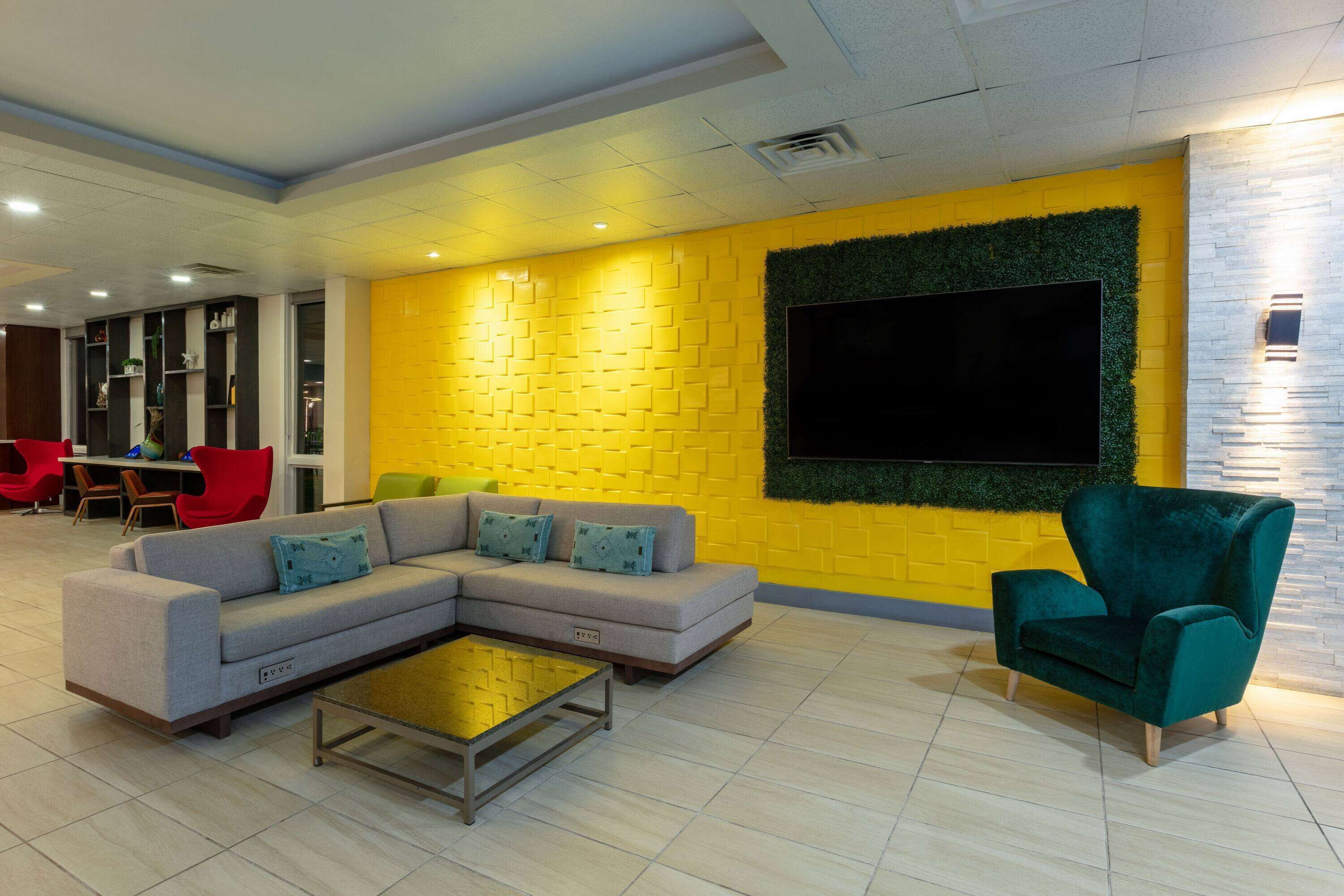 A modern living area with a sectional sofa, a green armchair, and a coffee table.