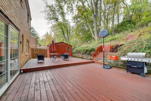 Une terrasse en bois avec un barbecue et du mobilier d’extérieur.