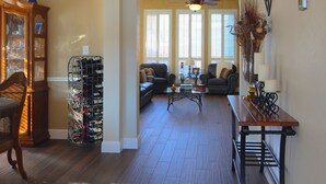 A spacious living area with a wooden floor, a ceiling fan, and a seating arrangement including a sofa and a chair. - West Plano Stay – Private Retreat Near AT&T Stadium for FIFA 2026 (Plano)