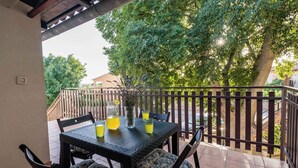 A balcony with a table set for two, equipped with chairs and a pitcher of lemonade. - Holiday apartment with air conditioning and barbecue (Peroj)