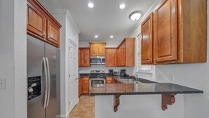 A kitchen with wooden cabinets, stainless steel appliances, and a granite countertop. - ☛5 Minutes from the Beach★ Pool/ Hot Tub★ Stocked☚ (Destin)