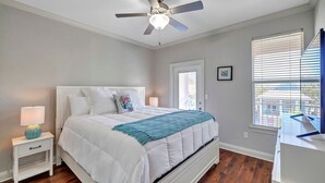 A bedroom with a bed, nightstand, lamp, ceiling fan, window with blinds, and a door. - ☛5 Minutes from the Beach★ Pool/ Hot Tub★ Stocked☚ (Destin)