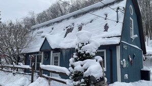 A snow-covered building with a blue exterior and a wooden mailbox. - Cozy Buckhannon Cottage, Panoramic Views, Koi Pond & Close to Town (Buckhannon)