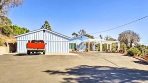 Ein eingeschossiges Gebäude mit Garage, einer überdachten Veranda und einem roten Lastwagen vor der Einfahrt.