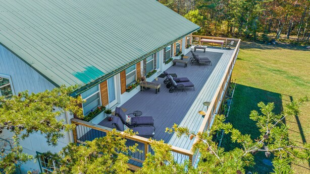 A house with a deck, outdoor furniture, and a view of the surrounding trees. - Wilderness Country Inn: France (Mentone)