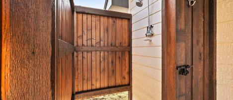 A wooden door with a metal handle and a small metal hook.