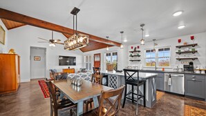 A spacious kitchen with a central island, wooden ceiling beams, and pendant lighting. - Texas Hill Country Escape in Hye, TX (Hye)