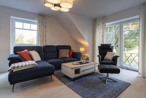 Un salon moderne comprenant un canapé, un fauteuil, une table basse et une lampe.