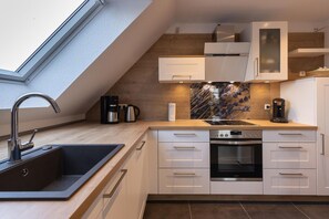 Een koelkast, een oven, een kookplaat, een vaatwasser