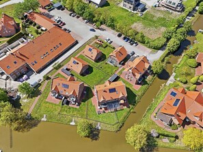 Oversigtsbillede af et boligområde med huse, en flod og en parkeringsplads.