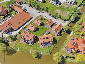 Eine Luftaufnahme eines Wohngebiets mit Häusern, einem Fluss und einem Parkplatz.