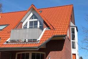 A red-tiled roof with a dormer window and a visible chimney. - Kyana - Schöne Ferienwohnung in Ruhiger Lage von Norden (Norden)
