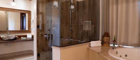 A modern bathroom with a glass-enclosed shower, a large bathtub, and a wooden vanity.