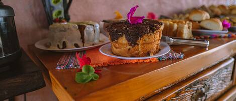 A dessert table with a cake, pastries, and a decorative flower.