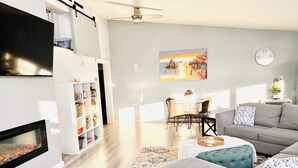Una sala de estar moderna con chimenea, comedor y un conjunto de sofás.