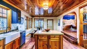 Une cuisine spacieuse avec des meubles en bois, un îlot central et une grande fenêtre.