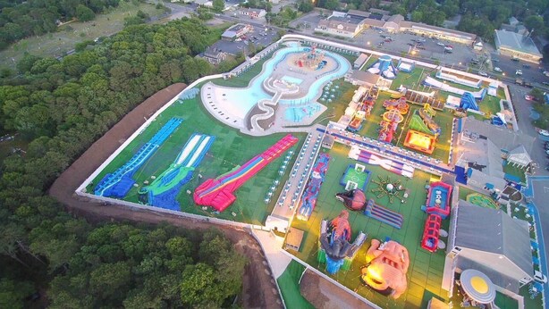 An aerial view of a theme park with various rides and attractions, surrounded by greenery and buildings. - Turtle Cove Cottage: Steps to Long Pond Beach (South Yarmouth)