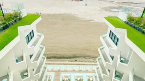 Un hotel moderno con piscina con vistas a la playa.