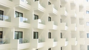 Un edificio moderno con varios balcones y ventanas amplias.