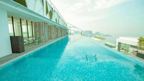 Una piscina infinita moderna con una vista despejada del horizonte de la ciudad.