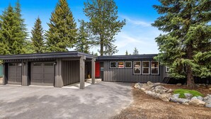 Un bâtiment moderne à deux étages, doté d’un garage et d’une allée couverte.