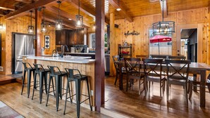 Un intérieur en bois comprenant une cuisine, un coin repas et des tabourets de bar.