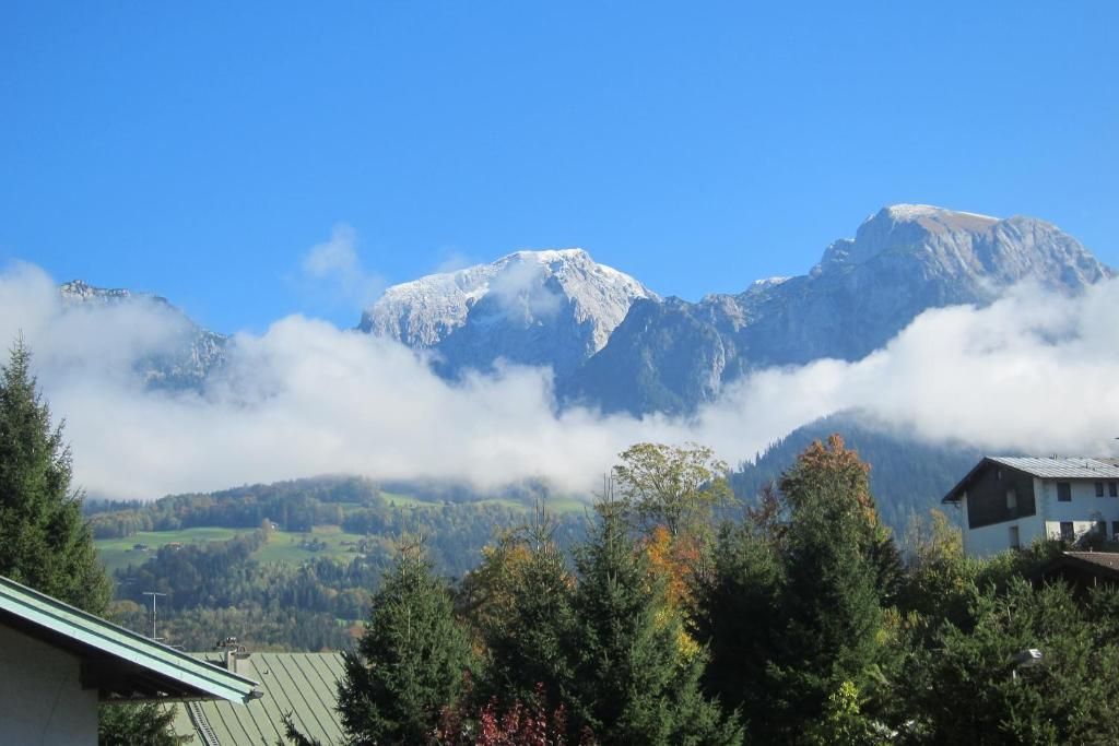 Un paisaje montañoso con una casa en primer plano.