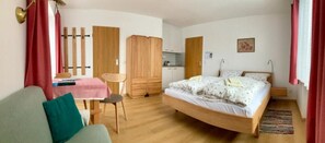 Ein Zimmer mit einem Bett, einem Schreibtisch, einem Stuhl und einem Kleiderschrank.